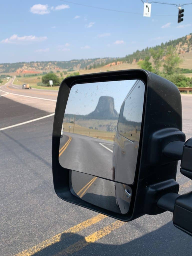 Devil's Tower stands in our vehicle's side mirror as we take the highway away from the park.