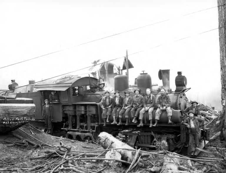 Lumberjacks rest on a locomotive in a historic photo from Silverton's past.