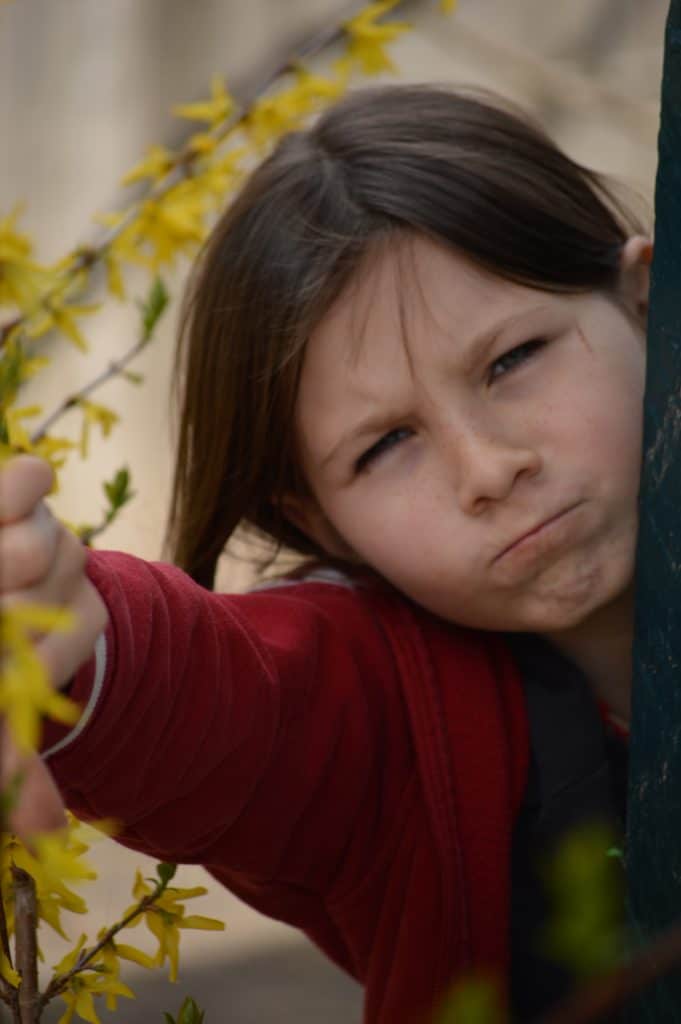 Girl making frown face with thumbs-down.