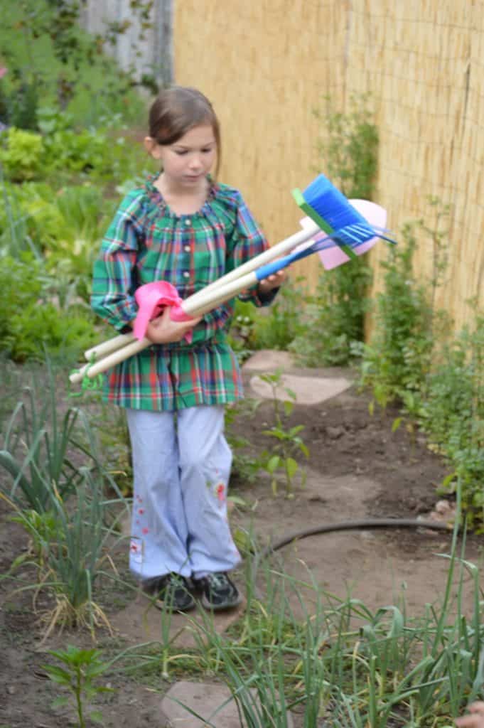 Girl carrying child sized rake, shovel and broom. non candy ideas for easter baskets