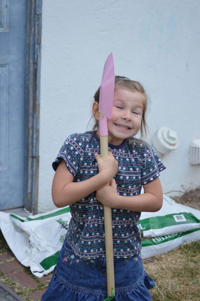 Girl holding garden shovel. non candy ideas for easter baskets