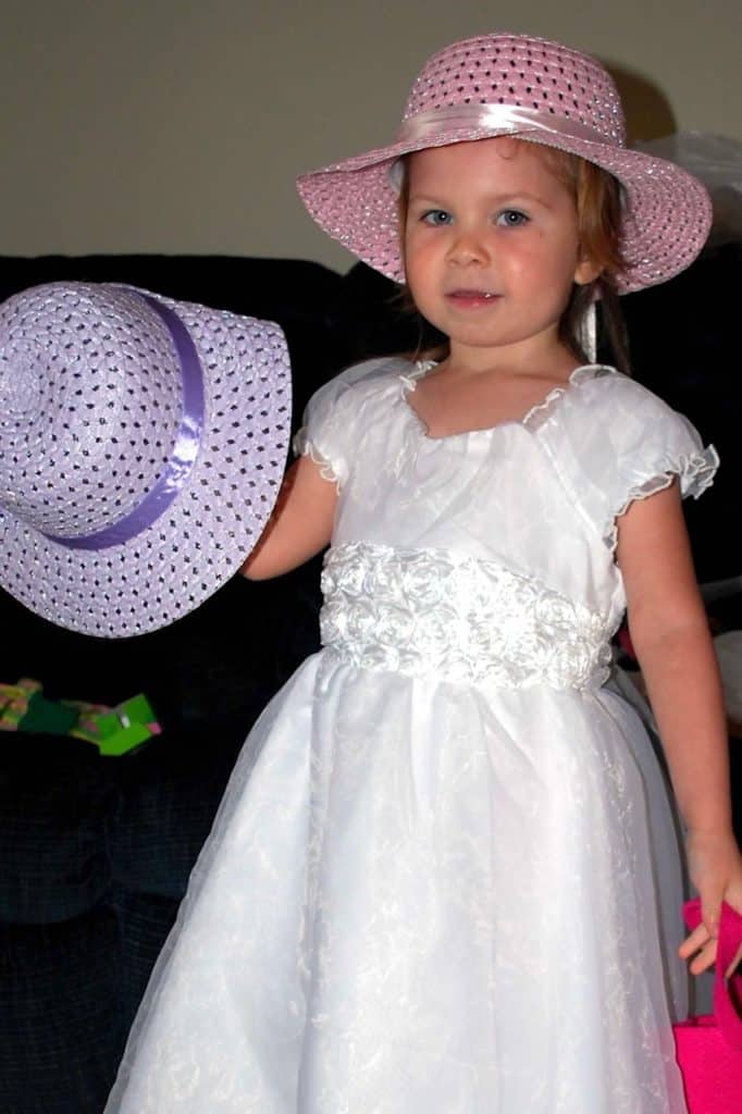 Girl in white easter dress and pink easter hat. non candy ideas for easter baskets