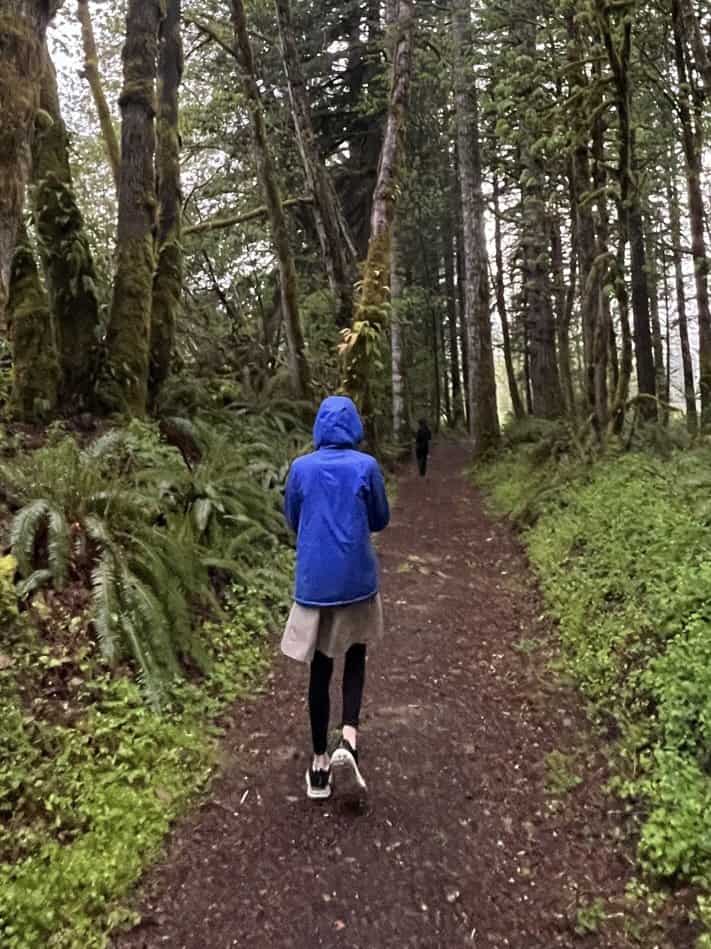 Girl walking through rainy forest. 