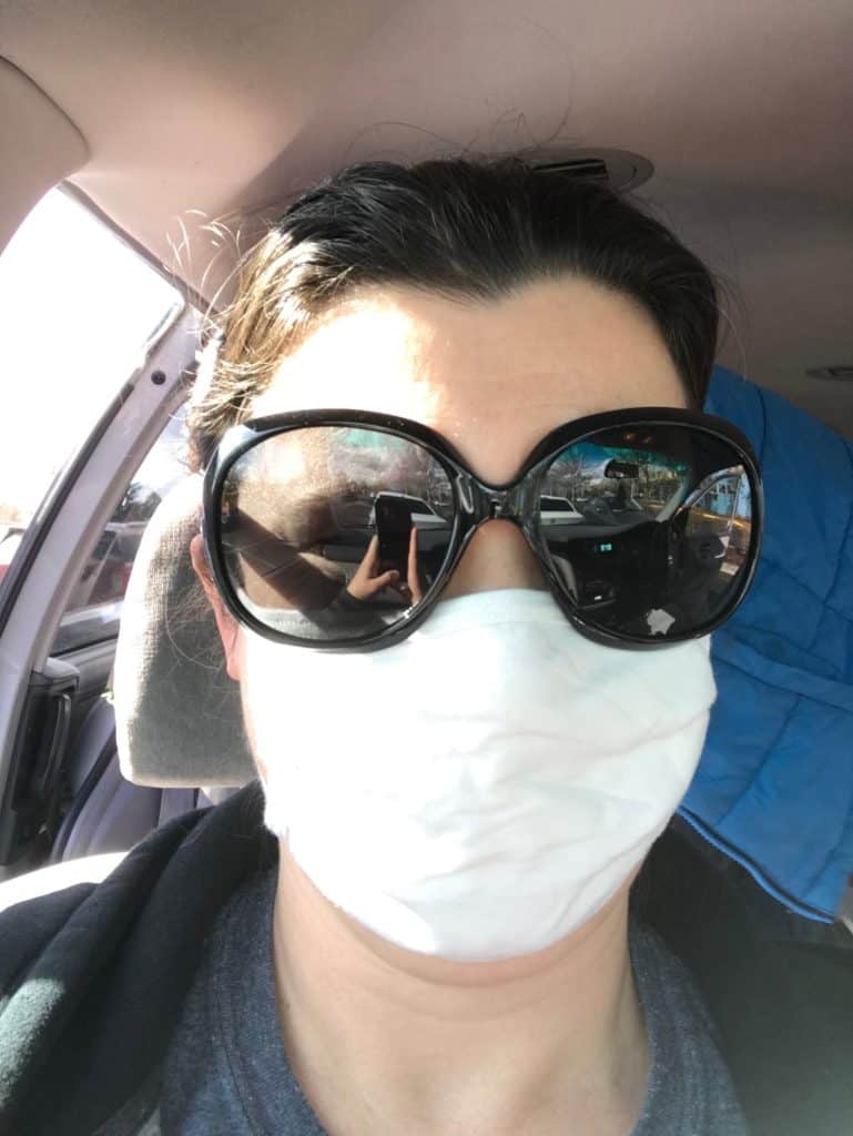 Woman in sunglasses and face mask.