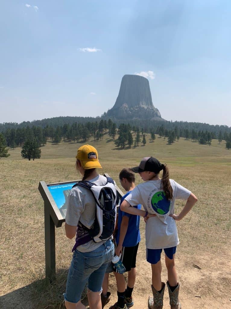 Three children look at an informative display at Devil's Tower National Monument. Devil's Tower National Monument is one of the best things to see along I-90 in Wyoming.