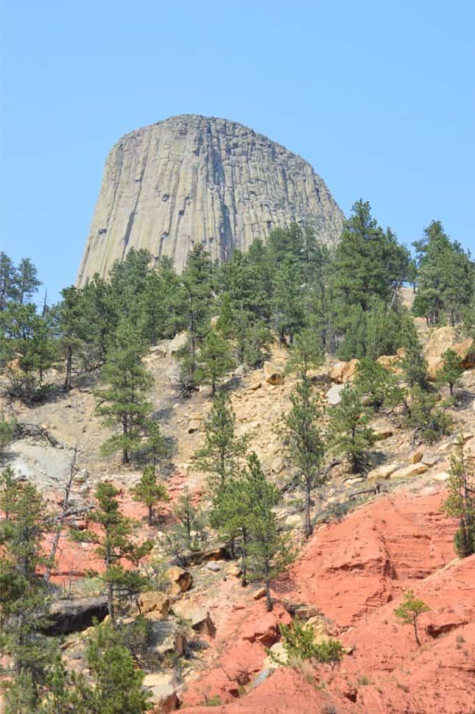 The top of Devil's Tower peeks out over surrounding hillsides.