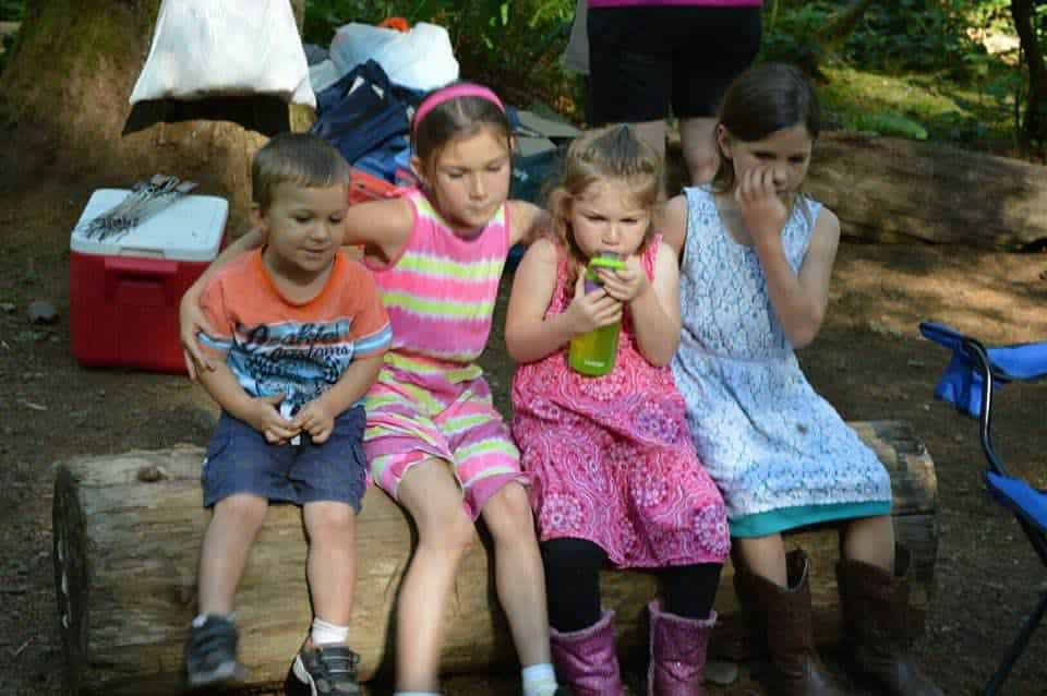 Kids sitting on a log.