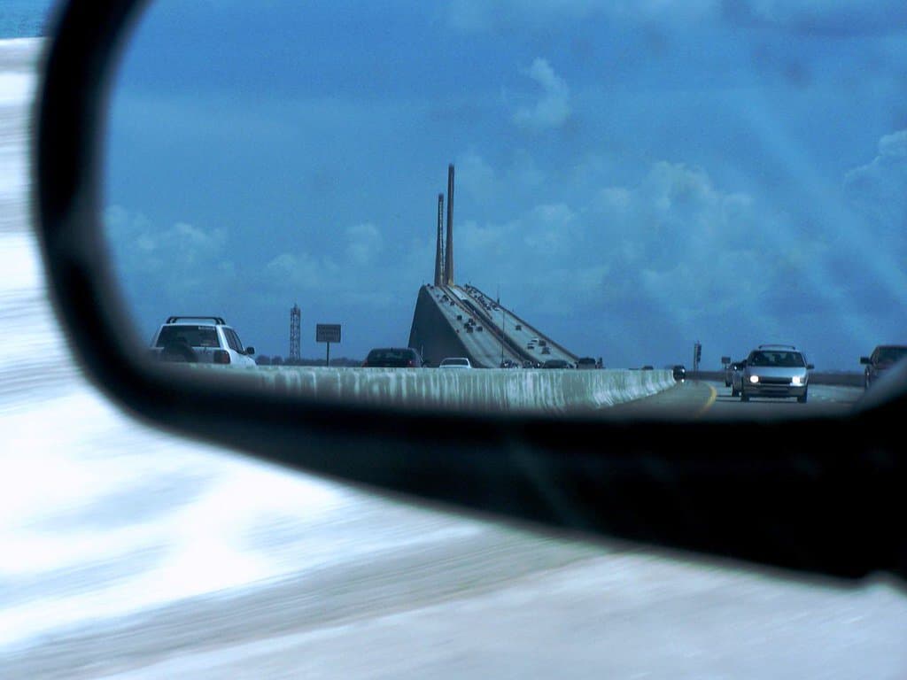 A rear-view mirror shows the Sunshine Skyway Bridge. Sunshine Skyway bridge is one of the highest bridges in the US.