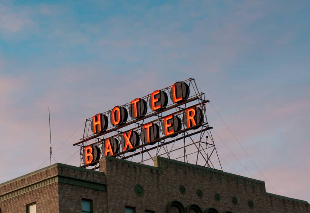 A neon sign that says "Hotel Baxter" sits atop the historic Hotel Baxter in Bozeman Montana. The Extreme History project is one of the 21 best museums in Bozeman.