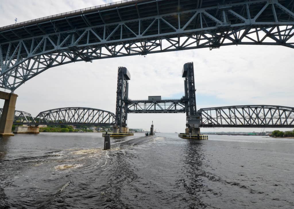 A submarine makes its way under the Gold Star Memorial Bridge. The Gold Star Memorial Bridge is one of the highest bridges in the US.