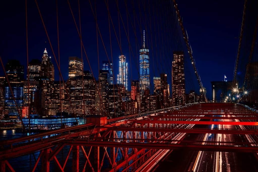The New York skyline shines amid the suspension wires of Brooklyn Bridge. Brooklyn Bridge is one of the highest bridges in the US.