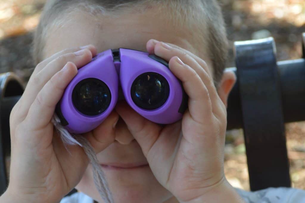 Boy with purple binoculars. camping gifts for kids and teens.