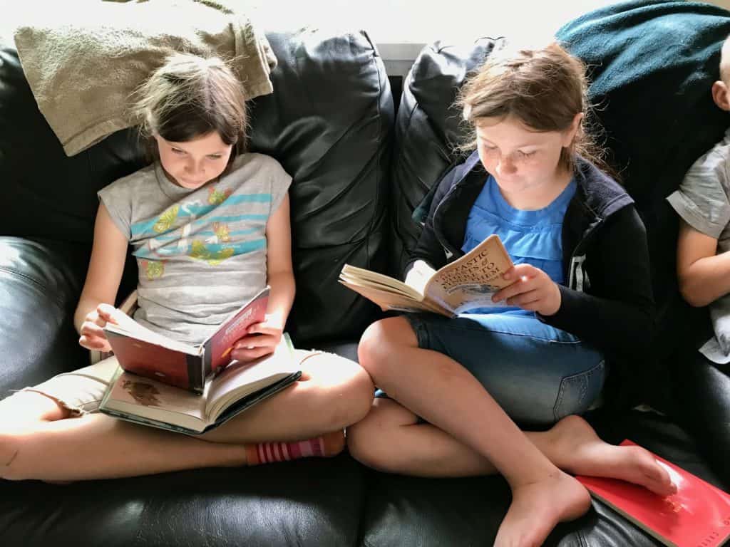 Girls reading on couch. Best science fiction books for 5th graders.