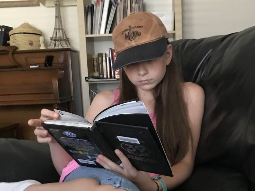 Girl reading 39 Clues book. Science fiction books for 5th graders.