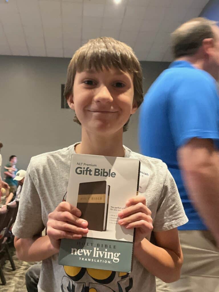 Our son holding his Gift Bible, NLT