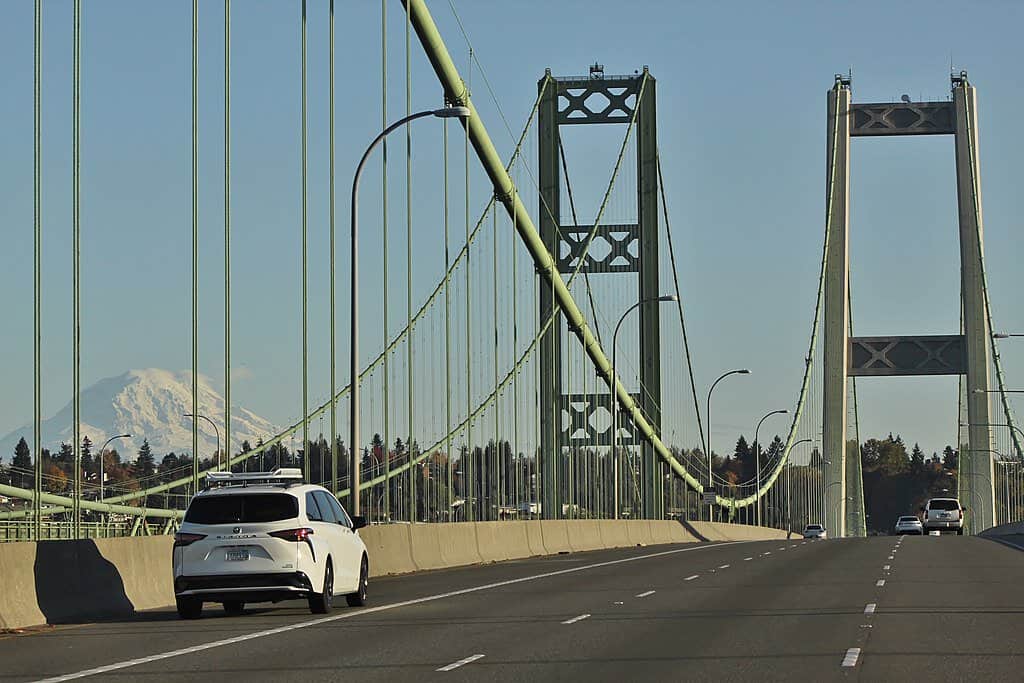 Cars cross the Tacoma Narrows Bridge while Mt. Rainer stands in the background.