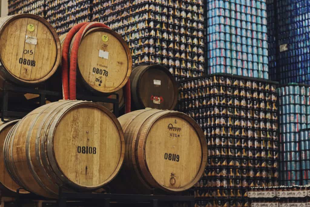 Blocks of stacked cans stand next to oak barrels at GoodLife Brewing in Bend, Oregon.