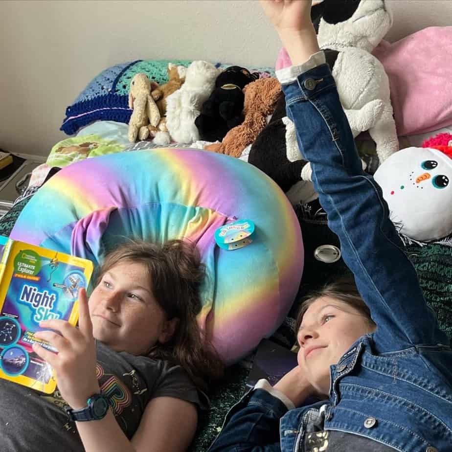 Girls hanging out on a bed. 