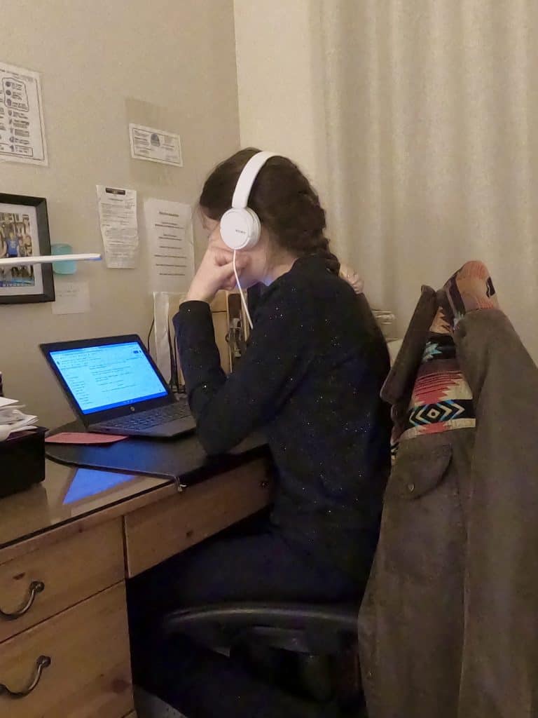 Girl working on computer at desk.