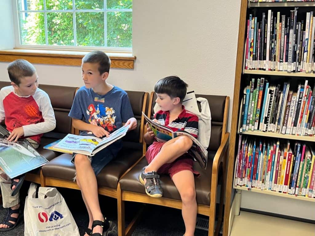 Boys reading books at the library. How to start homeschooling today.