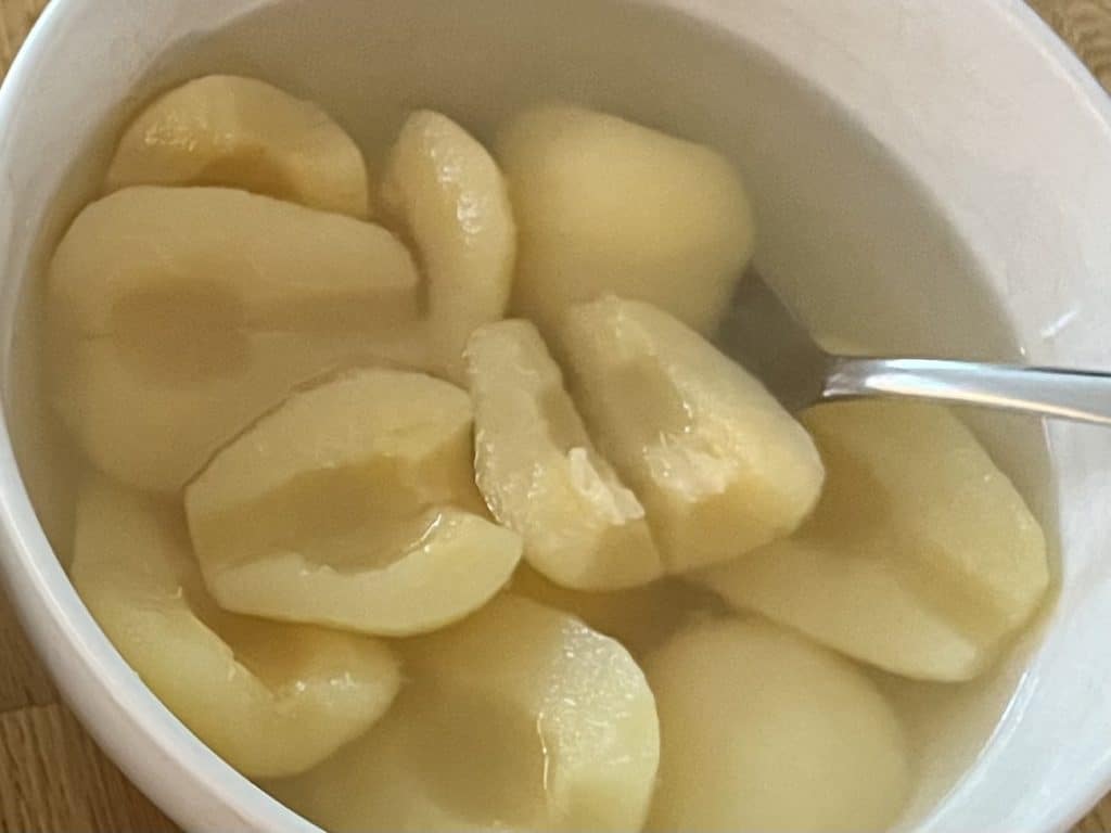 Canned pears in a bowl. best canned foods for camping