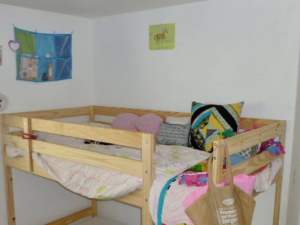 Girl's bed neatly made and organized. Calming ADHD bedroom ideas.