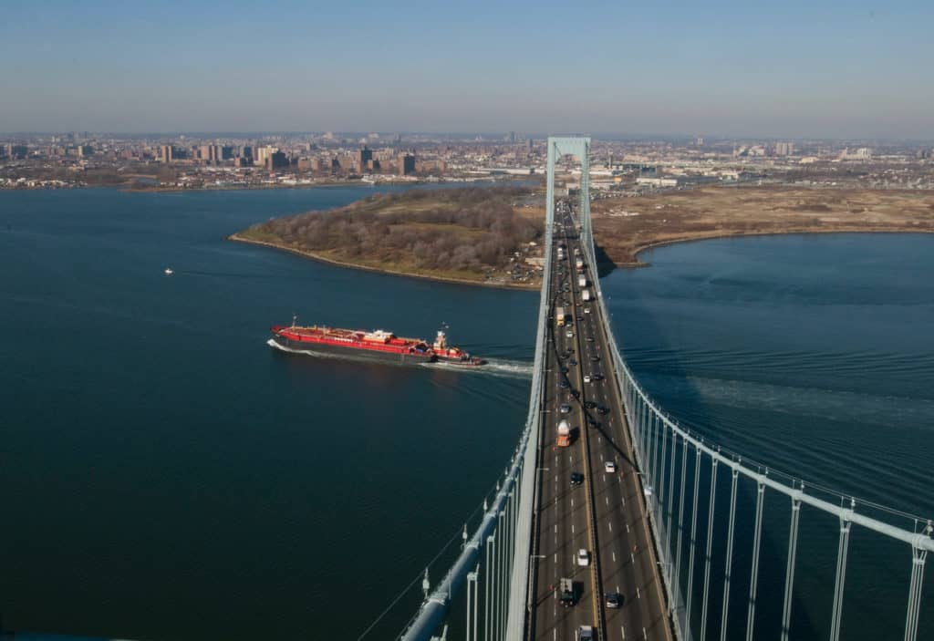 A picture taken from the very top of the Bronx-Whitestone bridge shows a barge recently emerged from under the bridge and traffic crossing on the bridge below.