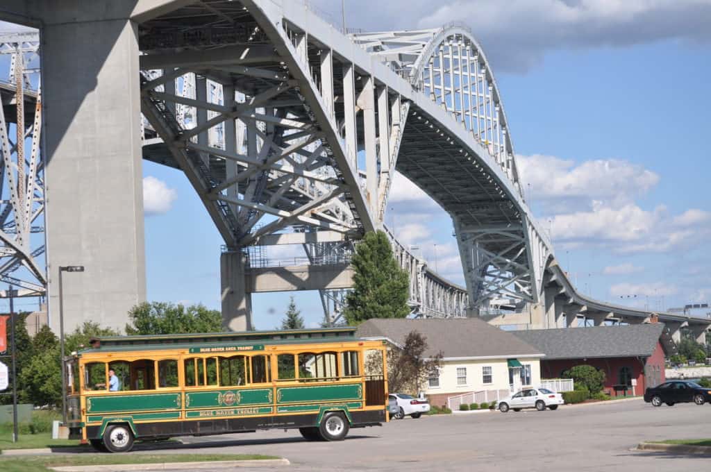 A trolley shuttle sits beneath one of the massive concrete pillars that holds up the Blue River Bridge.