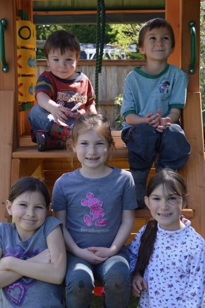 Kids sitting on a playground ladder. good sibling relationships.