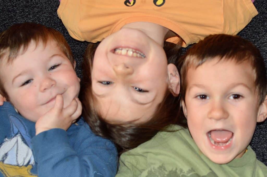 girl and boys laying on the floor.