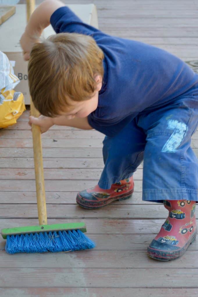 Boy sweeping a deck