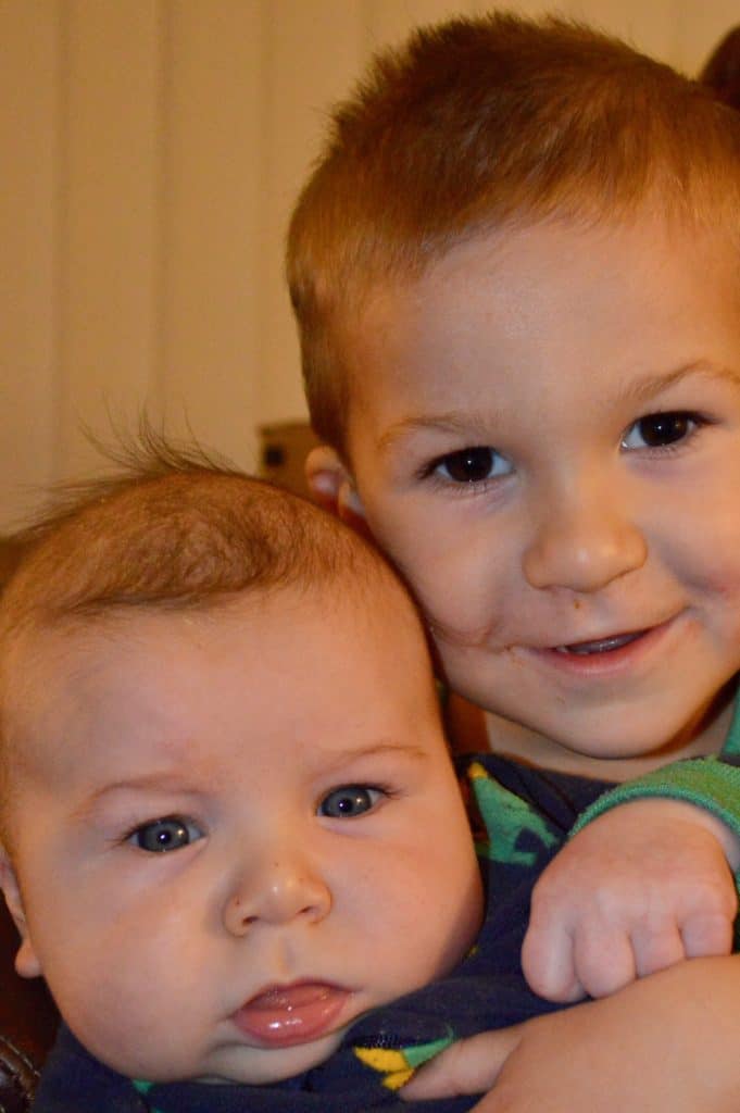 Toddler and baby smiling.