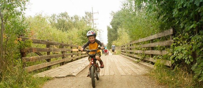 A boy bikes across a bridge along the Gallagator Trail. The Gallagator Trail is one of the best museums in Bozeman and the Gallatin area.