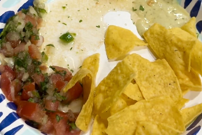 Chips and pico de Gallo on a paper plate. Camping lunch ideas