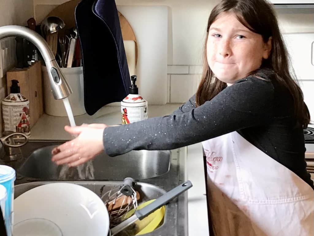 Girl doing dishes at the kitchen sink