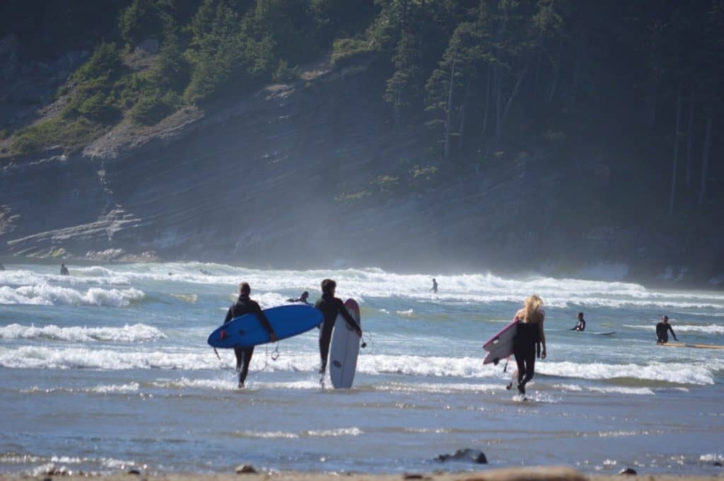 Surfers carry their boards along the shoreline at beautiful Short Sand Beach in Northern Oregon.