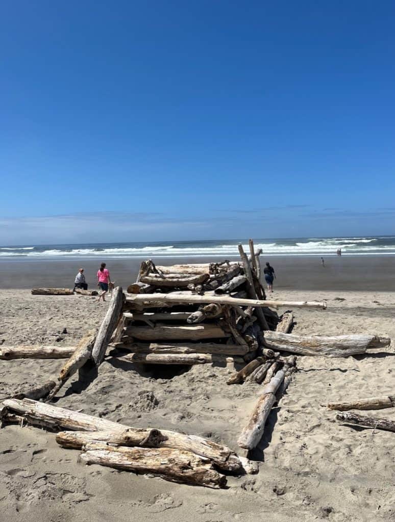 A driftwood structure stands at Nedonna Beach. Nedonna Beach is one of the best things to do on the Oregon Coast with kids.