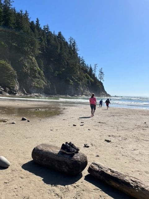 A pair of shoes sits on a log of driftwood as our children walk toward Short Sand Beach.
