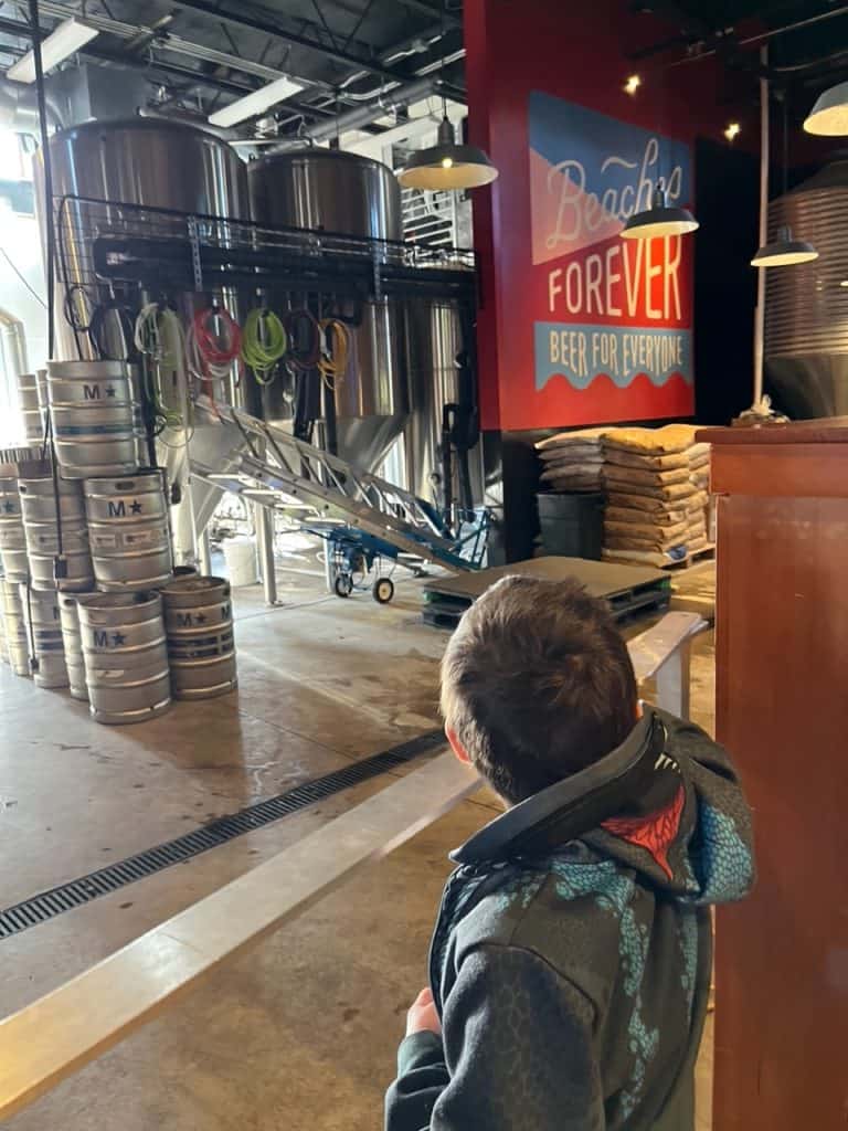 Our son looks out at the production facility at Public Coast Brewing Company.