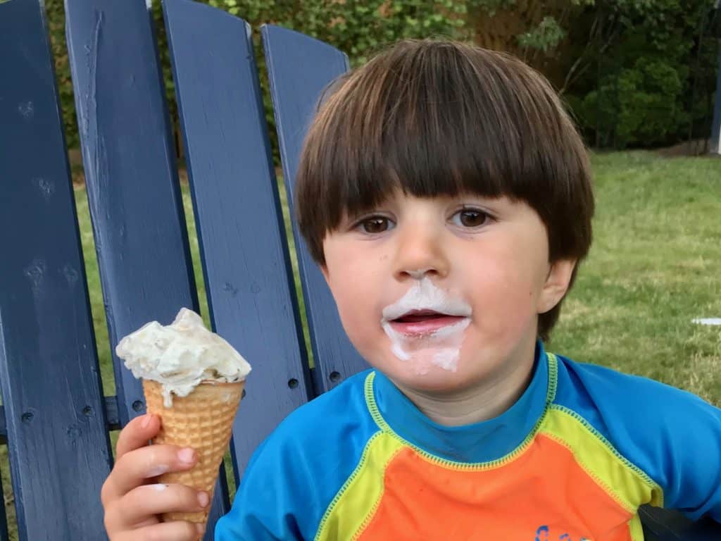 Kid in swimsuit eating ice cream cone