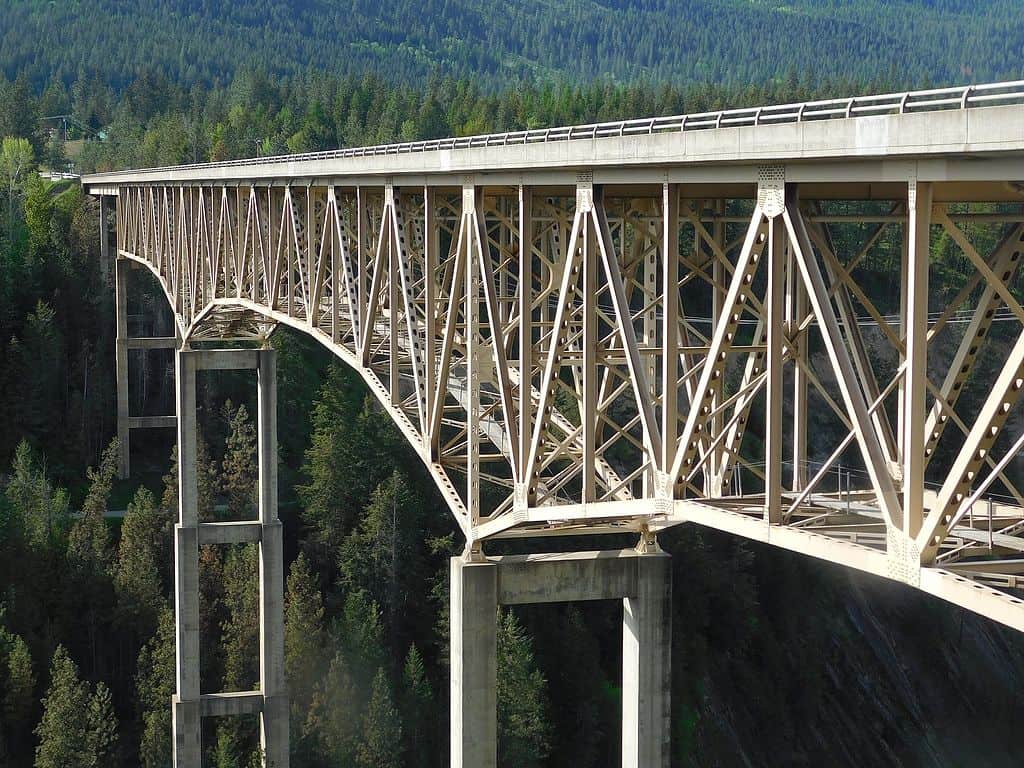 The Moyie River Canyon Bridge dwarfs tall pine trees in Northern Idaho. Moyie River Canyon Bridge is one of the highest bridges in the US.