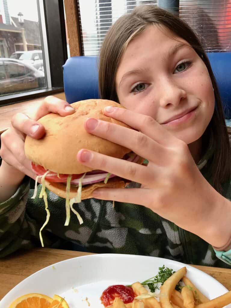 Girl eating a burger at Pig N' Pancake in Seaside Oregon.