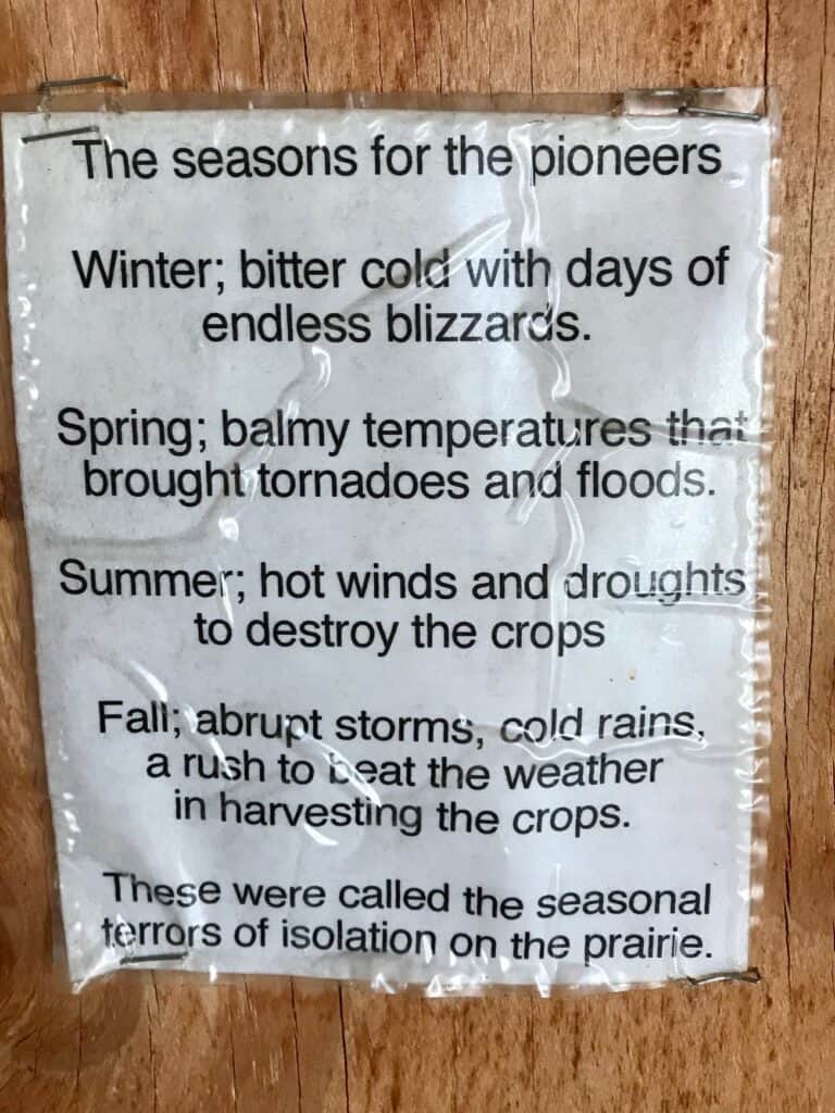 Sign depicting "The Seasons for the pioneers" describing the difficulties of farming in pioneer days.