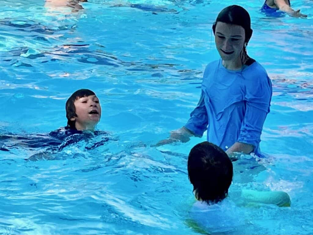 Our teen daughter in the pool with her younger brothers. The Astoria Aquatic Center is one of the best things to do in Astoria Oregon with kids.