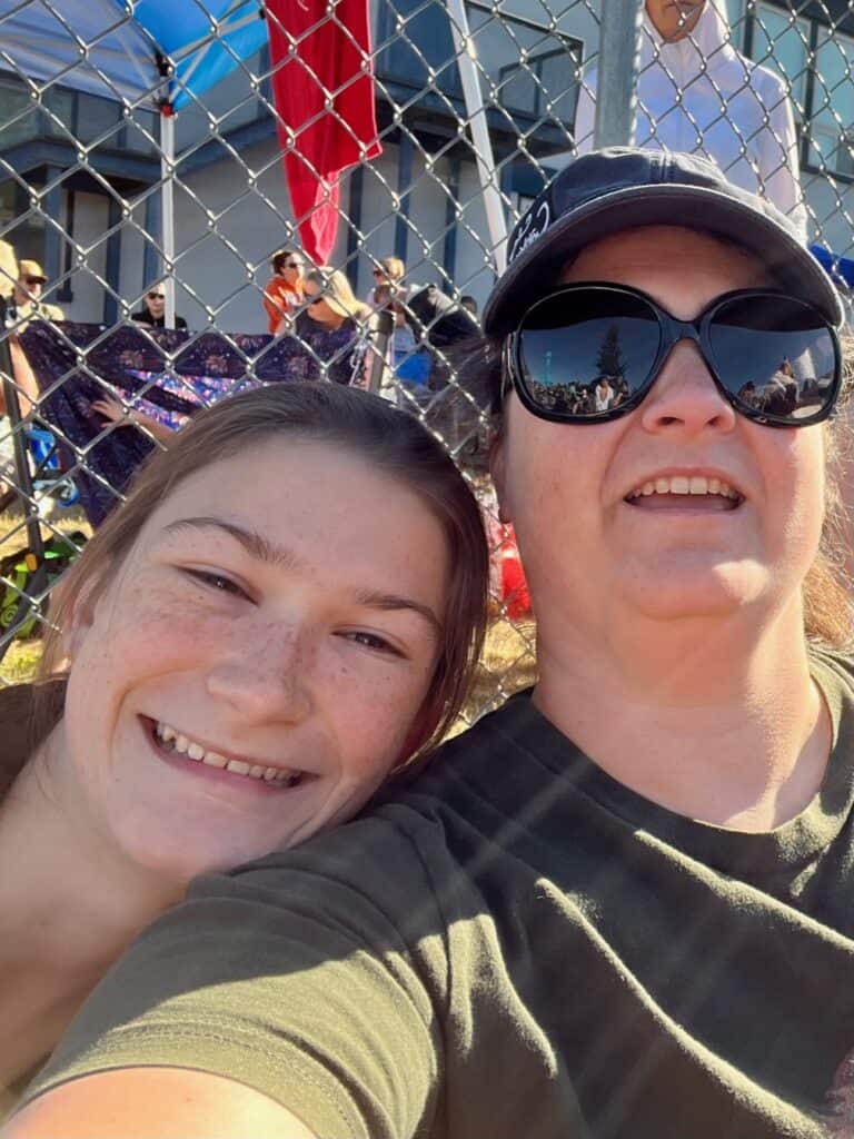 Jenn and daughter Rook on the sidelines supporting siblings at a competition.