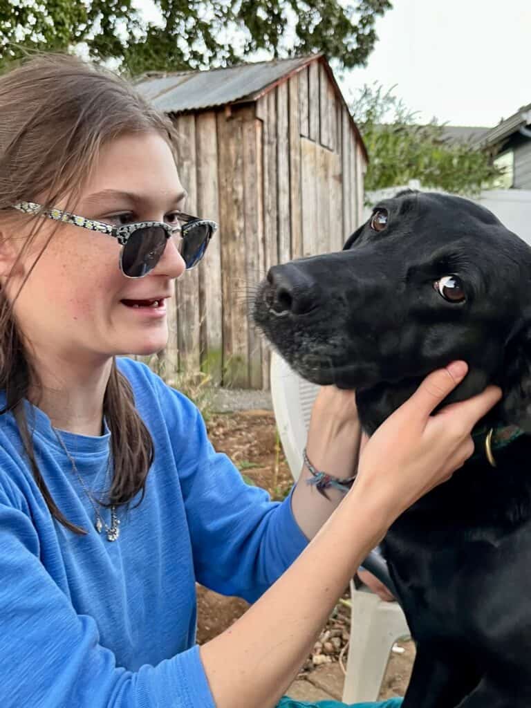 Rook petting our black Labrador dog.