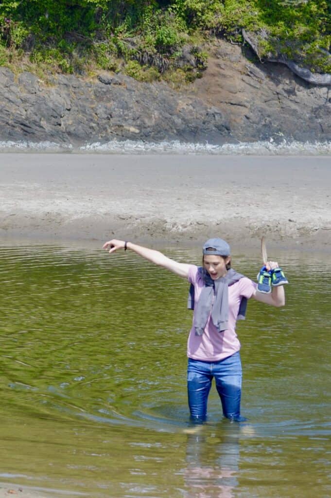 Our oldest daughter wades a creek while carrying her little brother's shoes.