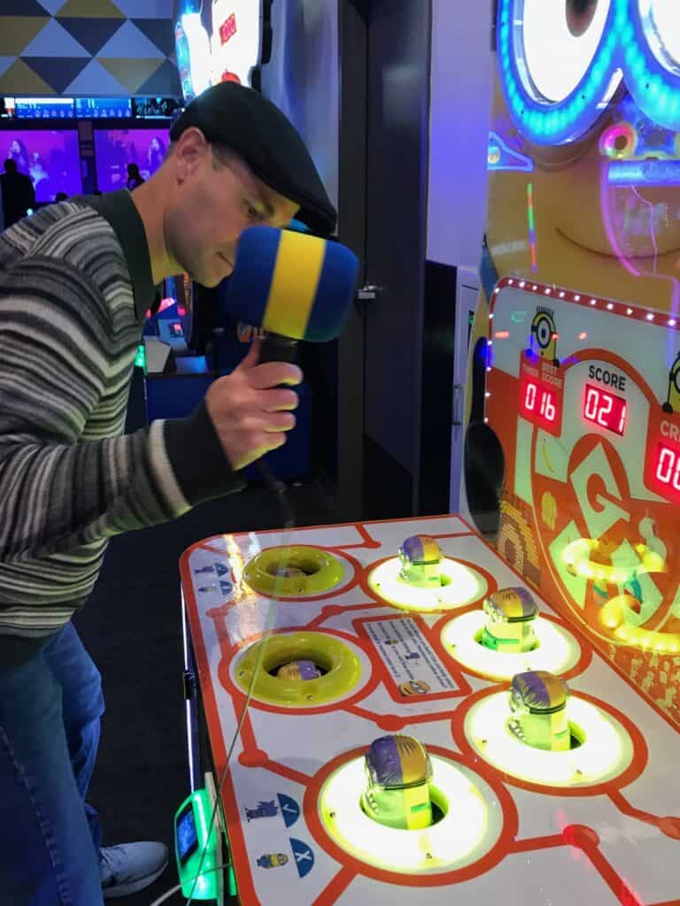 My husband playing Whack-A-Minion an an arcade.