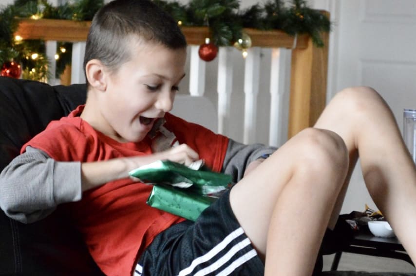 My son opening a green Christmas gift. 