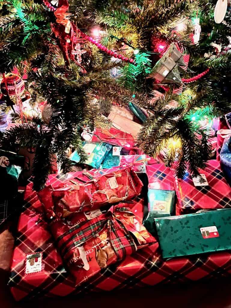 Christmas gifts under a lighted Christmas tree at our house.